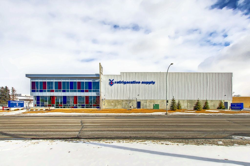 The exterior of the Refrigerative Supply building. The company sign and logo is on the right hand side of the building. Blue and red windows are on the left side.